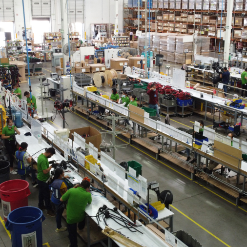 Close up view of someone sitting at a laptop on a table full of various engineering and construction equipment.
